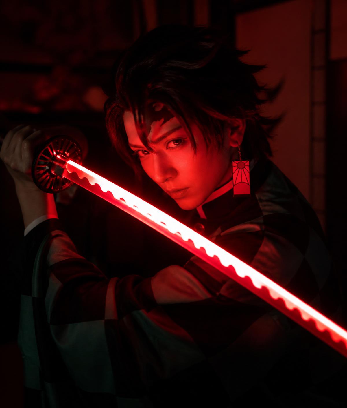 Cosplayer wielding a glowing red LED Nichirin katana in a dark room